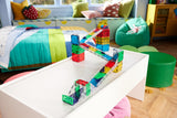 Colorful Rail Racers Deluxe - 90 Piece Set on a white surface in a child's playroom with colorful furniture and toys.